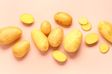 Obraz premium Cut and whole raw potatoes on pink background