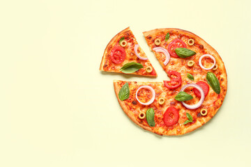 Tasty pizza with olives, tomatoes and basil on light green background