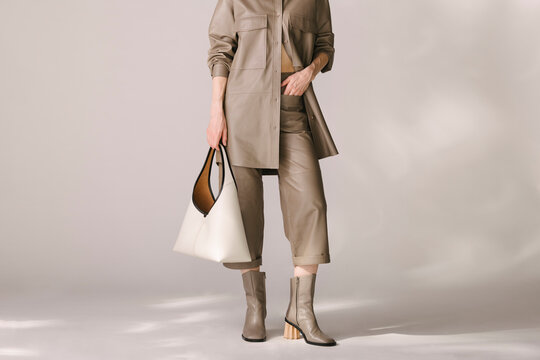 Stylish Woman in Beige Outfit Holding Designer Handbag