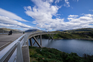 Obraz premium The image is of the Kylesku Bridge in Scotland, which spans Loch a' Chàirn Bhàin in Sutherland. It is a concrete bridge. 