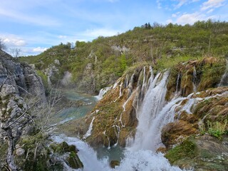 A mesmerizing cascade of water rushes down a rugged rock face in Plitvice, Croatia
