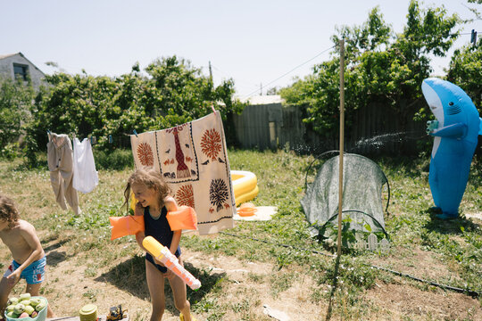 Summer day fun: father in shark costume playing with children