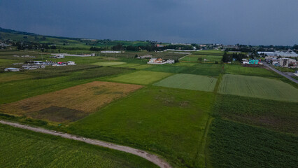 Aerial photography taken with a drone, of the Ixtlahuaca State of Mexico countryside, where mountains, cornfields, and old houses can be seen.