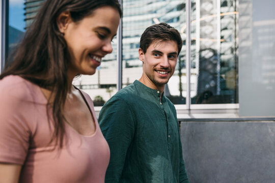 Smiling friends walking in Azca, Madrid during the day