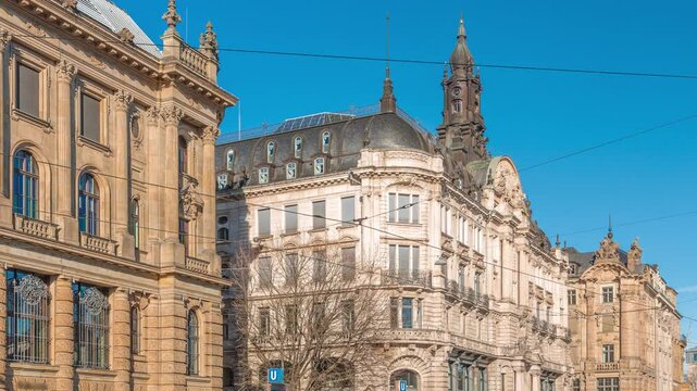 Historical houses on Lenbachplatz square timelapse in Munich, Germany. Traffic on the street and rails with trams. Sunny day with blue sky