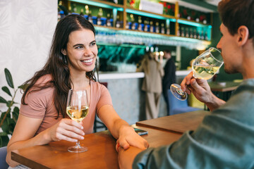 Couple enjoying wine at a bar, engaging in a lively conversation