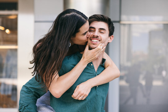 Young couple embracing and smiling outdoors in Azca, Madrid
