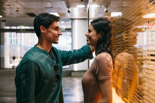 Couple smiling and talking near a window in Azca, Madrid