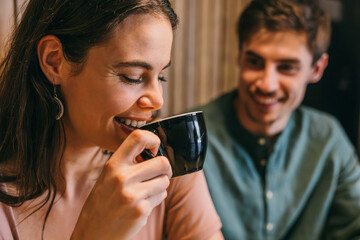Close-up of friends sharing coffee and laughter in a cozy cafe