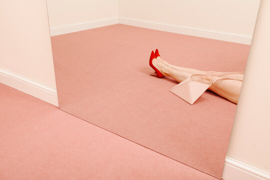 Woman Lying On Pink Carpet With Red Heels Near Mirror