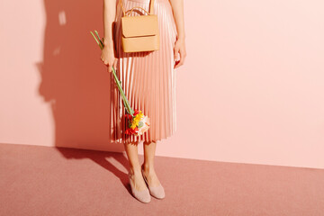Elegant Woman Holding Flowers in Beige and Pink Outfit