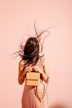 Fashionable Woman With Handbag Against Pink Background