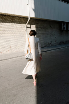 Woman Walking in Urban Alley in Daylight