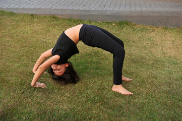 menina fazendo exercicios ponte na grama 