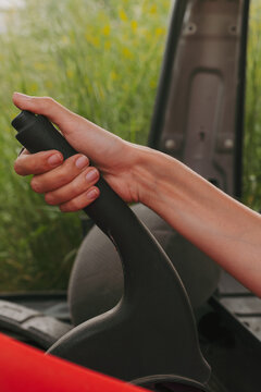 Hand Gripping Gear Shift in Vehicle Surrounded by Greenery