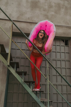 Woman Walking Up Stairs With  swimming mattress