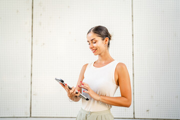 Young woman stand in front white background and use digital tablet