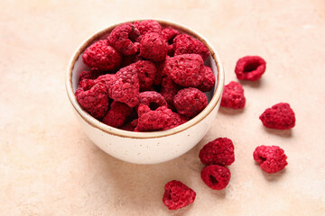 Bowl of dehydrated raspberries on beige background
