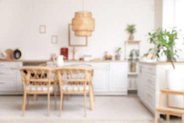 Dining table with chairs in modern kitchen. Blurred view