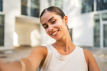 Self portrait of beautiful smile young woman stand in front building