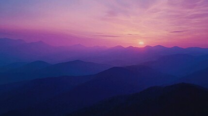 Fototapeta premium The sun sets over a mountain range in a bird's-eye view