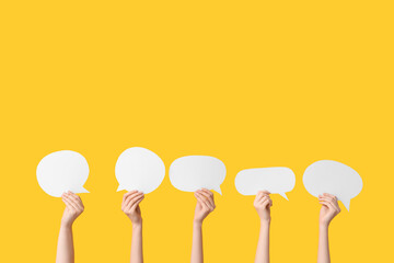 Female hands with speech bubbles on yellow background