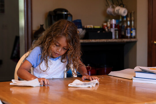 Young Girl Cleaning Kitchen Table After Project
