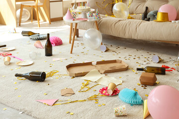 Carpet with rubbish and party decor in messy living room after Birthday celebration