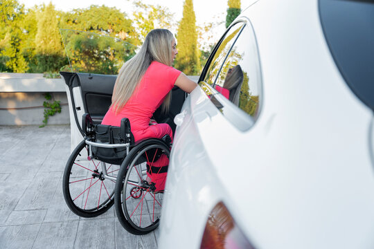 Person in wheelchair getting out of car