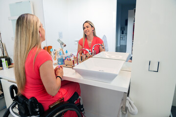 Woman in wheelchair applying makeup at bathroom vanity