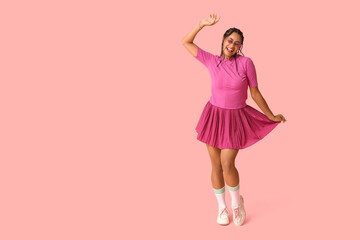 Beautiful young African-American woman with dreadlocks on pink background