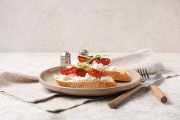 Plate of tasty tomato bruschetta with ricotta on white background