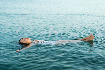 Little girl lying on her back in the sea