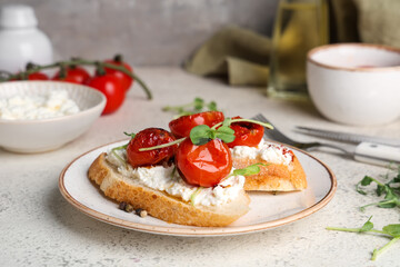 Plate of tasty tomato bruschetta with ricotta and micro green on white background