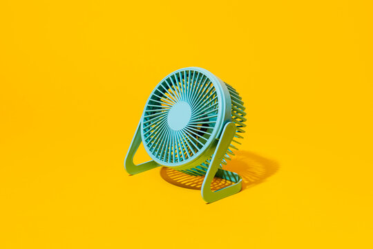 blue electric fan on a yellow background