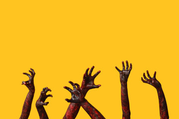 Many hands of zombies on yellow background. Halloween celebration