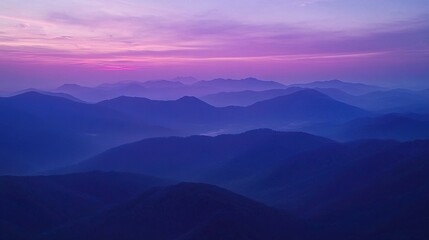 Obraz premium A mountain range with a pink sky in the background and foreground