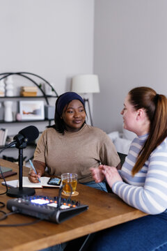 Black podcaster interviewing guest for social media channel at home 