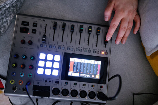 Cropped photo of anonymous woman making adjustments on audio mixer 