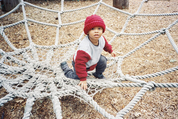 Toddler Playing in Spider Web Net at Playground