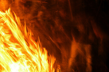 firewood burns, fire coals at night. Red hot coals glowing on a dying campfire pit. Orange glow...