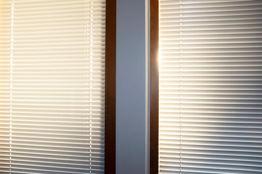 Golden hour sunlight beam of light and minimal window with blinds