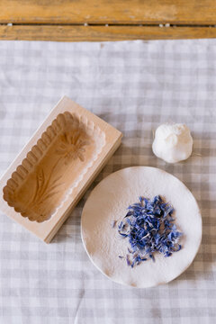 Wooden butter mold and plate with edible flower petals.