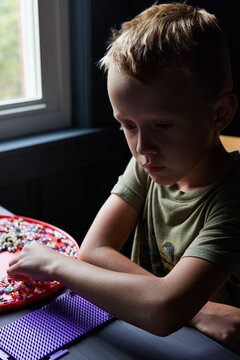 Little boy doing perler beads