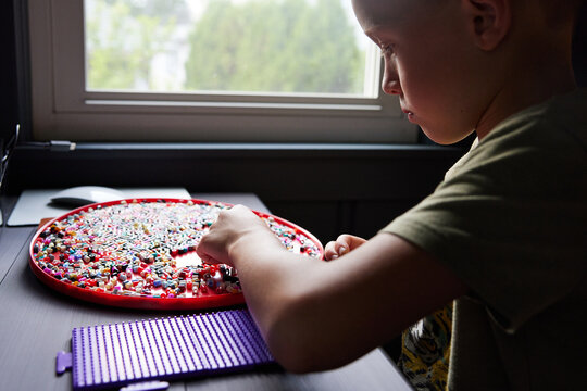 Little boy doing perler beads