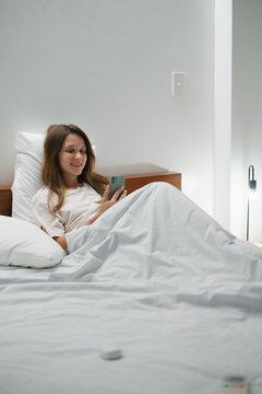 Relaxed Woman Using Smartphone in Bed