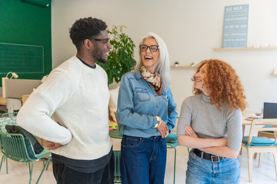 Group Of Three People Talking And Laughing