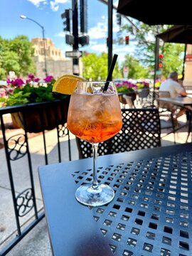 Having an Aperol spritz at a sidewalk cafe 

a sidewalk cafe