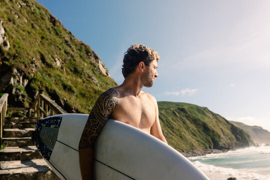 Surfer looking at the horizon identifying the perfect spot to surf