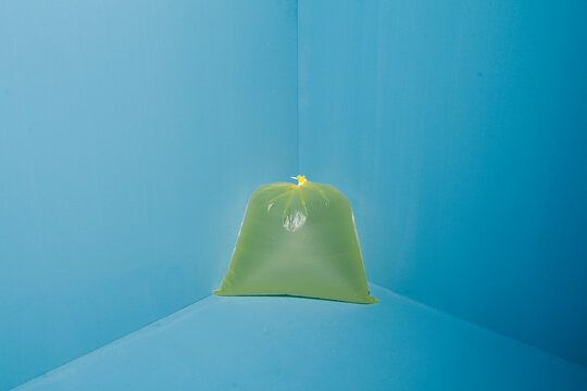 Green Trash Bag in Bright Blue Room with Minimalist Style